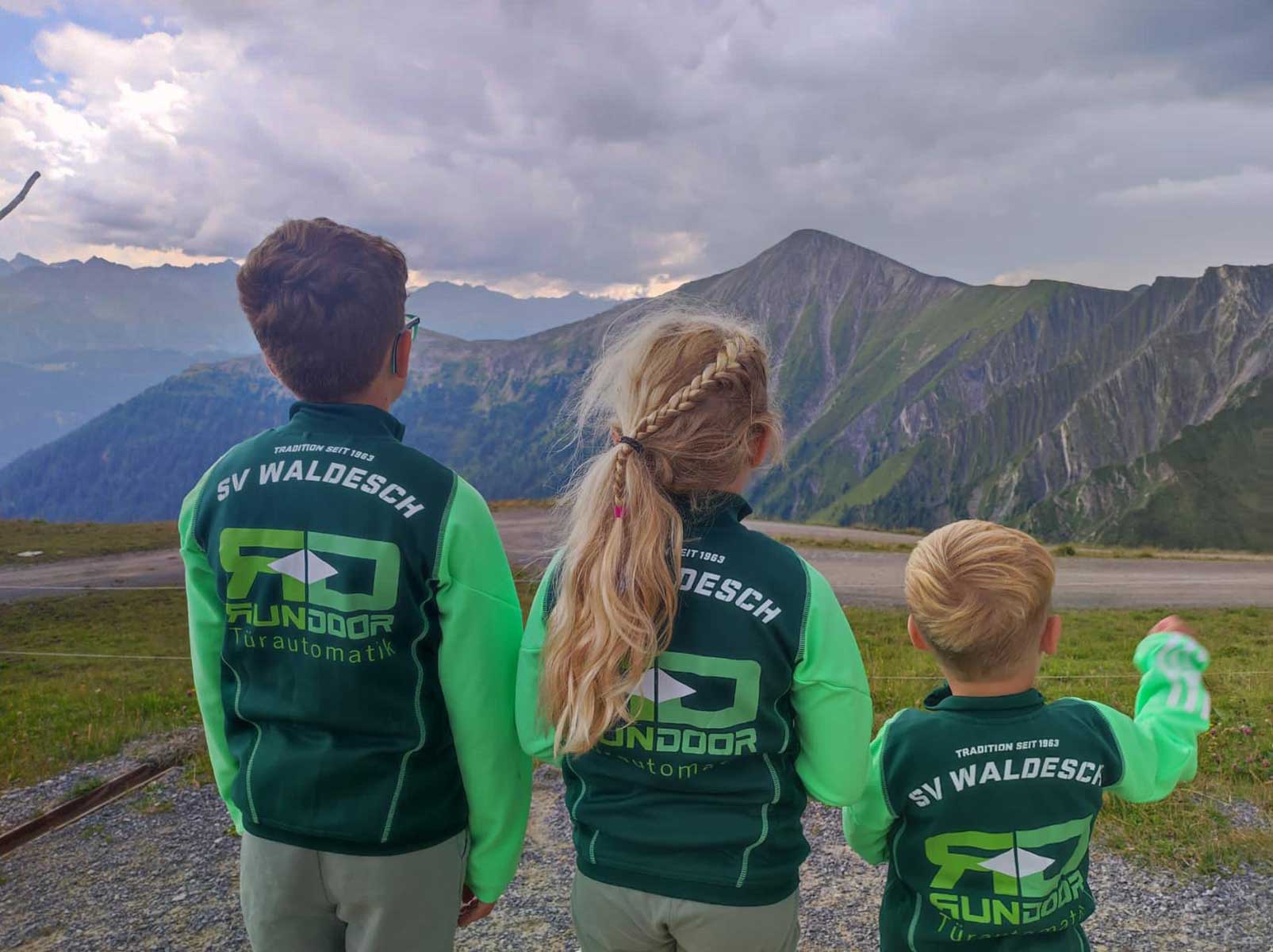 Trikot auf Tour - Vier Kinder und Berge im Hintergrund